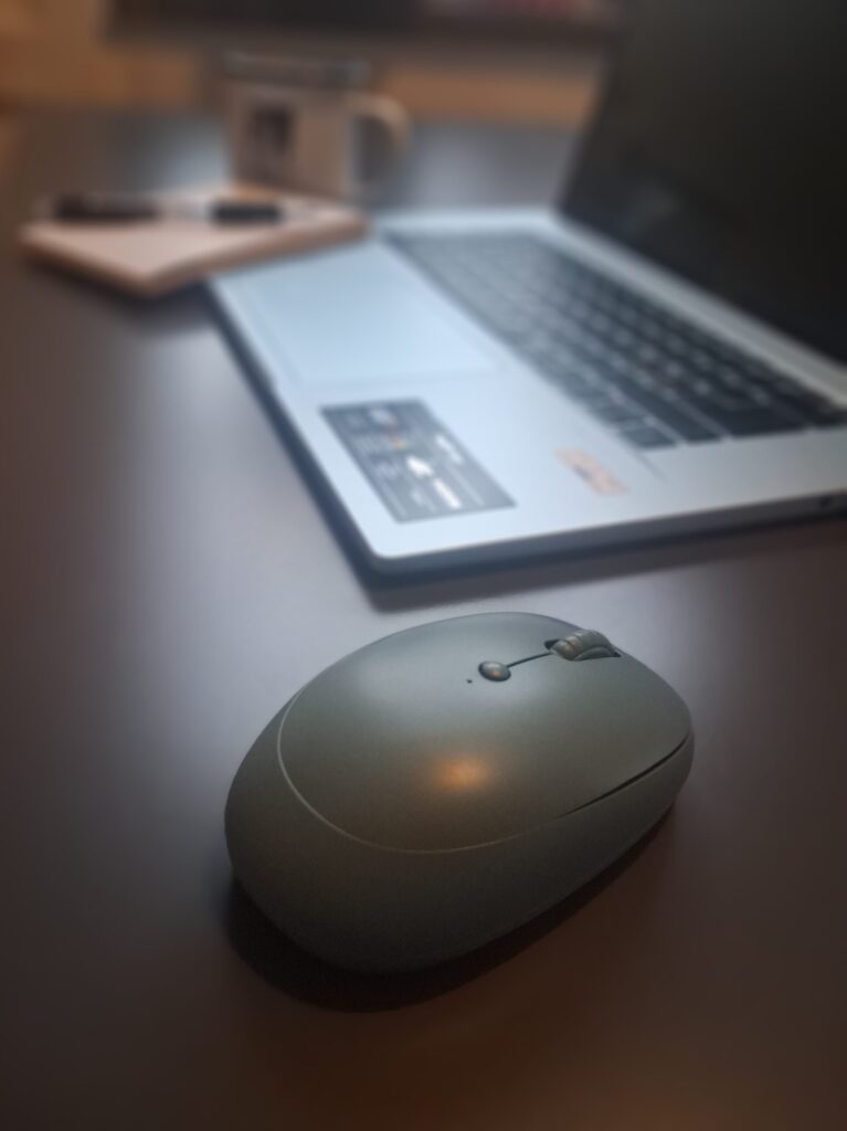 Laptop and mouse on a desk representing using AI at work in a focused workspace.