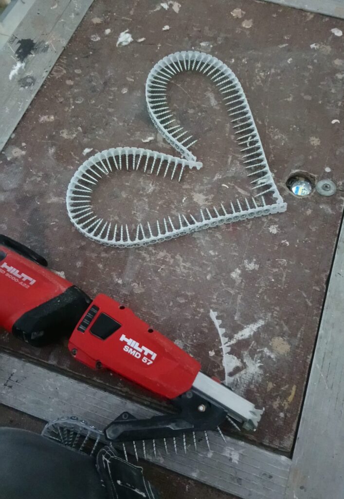 Collated screws in a heart shape on a workbench, illustrating the difference between forgettable company content and concrete detail