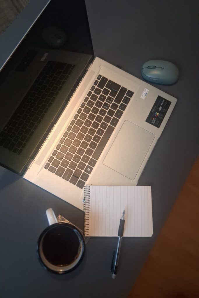 Laptop, notebook and coffee mug on a desk while planning how to start freelancing.